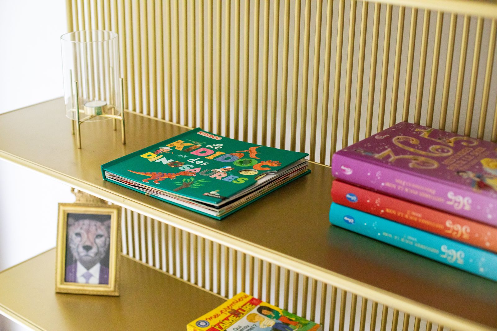 Étagère dorée, livres et cadre